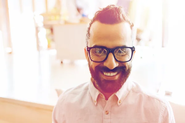 Uomo sorridente con occhiali e barba all'ufficio — Foto Stock