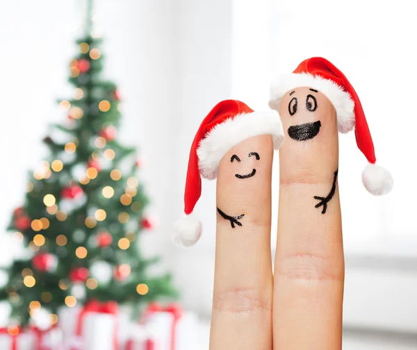 Close up of two fingers with smiley and santa hats — Stock Photo, Image