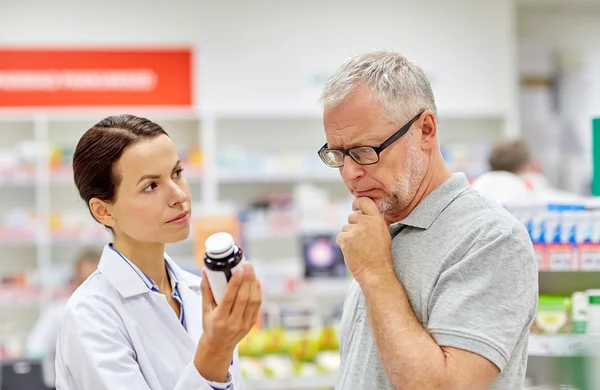 Apotheker zeigt Senior in Apotheke Medikament — Stockfoto