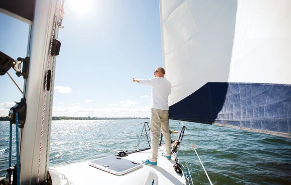 Homem sênior em barco à vela ou iate navegando no mar — Fotografia de Stock