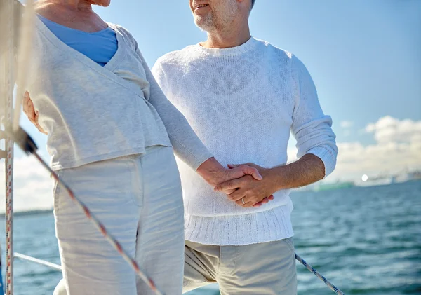 Счастливая старшая пара на парусной лодке или яхте в море — стоковое фото