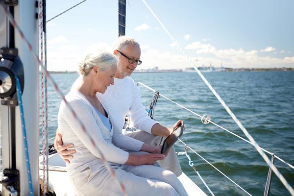 Senior paar met de tablet pc op zeilboot of jacht — Stockfoto