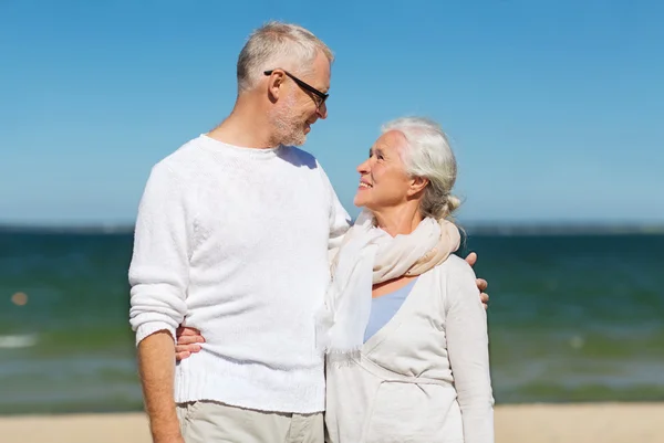 Счастливая пожилая пара обнимается на летнем пляже — стоковое фото