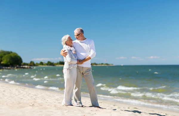 Feliz pareja de ancianos tomados de la mano en verano playa — Foto de Stock