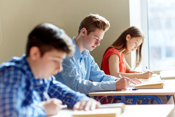 Gruppo di studenti con libri prova di scrittura scolastica — Foto Stock