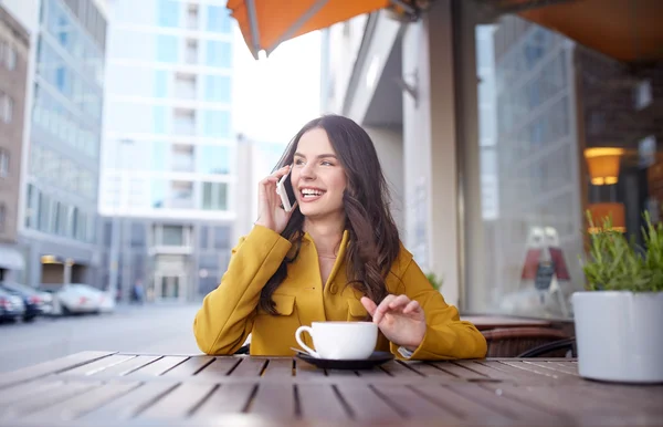 Счастливая женщина звонит на смартфон в городском кафе — стоковое фото