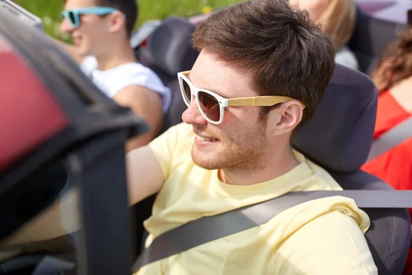 Amigos felizes dirigindo em carro cabriolet — Fotografia de Stock