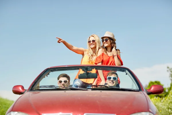 Amigos felizes dirigindo em carro cabriolet no país — Fotografia de Stock