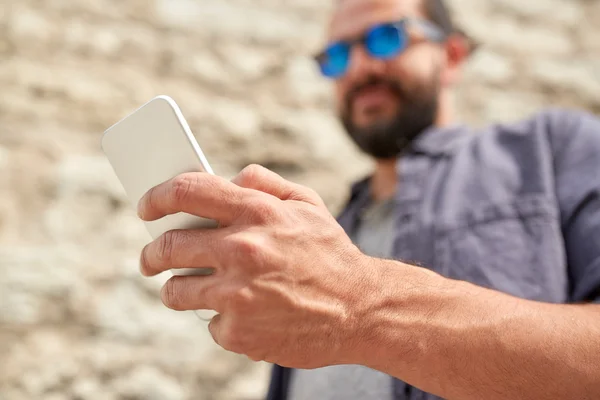 Close up of man with smartphone at stone wall — Stock Photo, Image