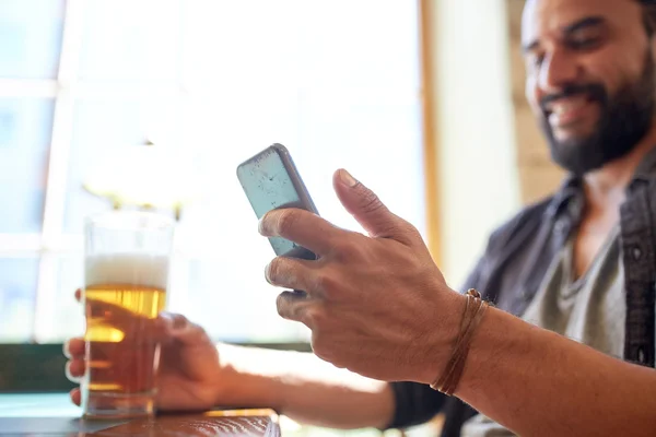 Primer plano del hombre con smartphone y cerveza en el pub — Foto de Stock