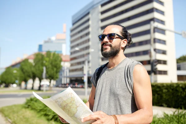 Человек путешествует с рюкзаком и картой в городе — стоковое фото