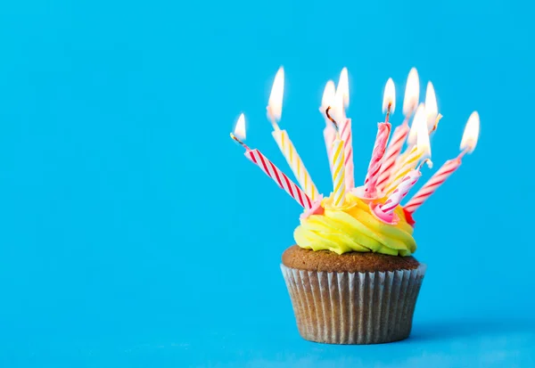 Cupcake de aniversário com muitas velas em chamas — Fotografia de Stock