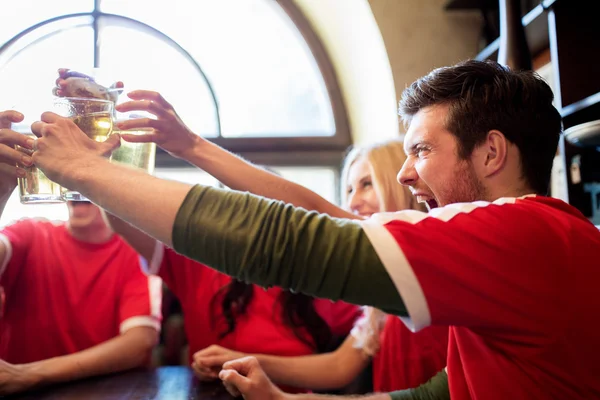 Fußballfans klirren an Sportbar mit Biergläsern — Stockfoto