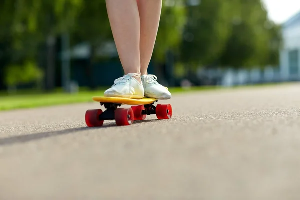 Gros plan de pieds féminins chevauchant skateboard court — Photo