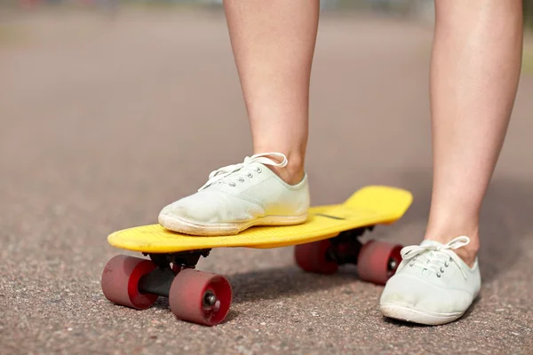 Primo piano di piedi femminili cavalcando skateboard corto — Foto Stock