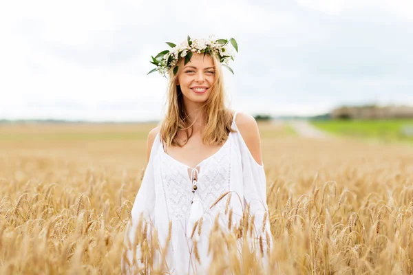 Happy young woman in flower wreath on cereal field — Stock Photo, Image