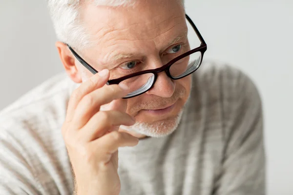 Close up of senior man in glasses thinking — Stock Photo, Image