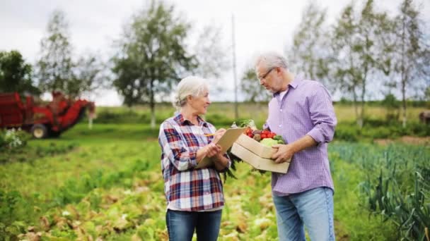 Pareja de ancianos con caja de verduras en la granja — Vídeos de Stock