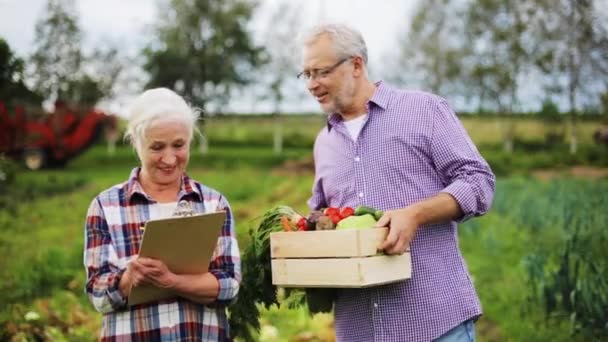 Äldre par med låda grönsaker på gården — Stockvideo