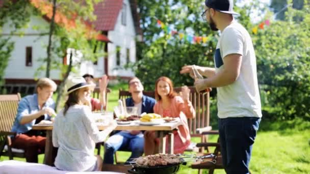 Друзья устраивают барбекю в летнем саду — стоковое видео