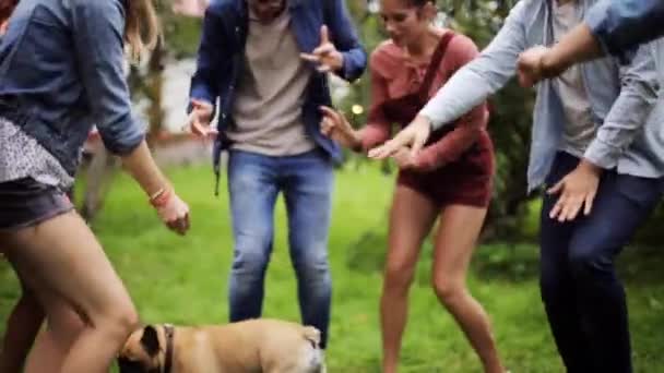 Happy vrienden dansen op zomer party in de tuin — Stockvideo