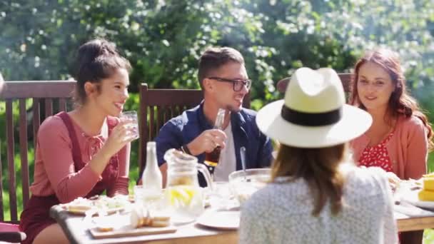 Ευτυχείς φίλοι έχοντας το γεύμα στο καλοκαιρινό πάρτι στον κήπο — Αρχείο Βίντεο