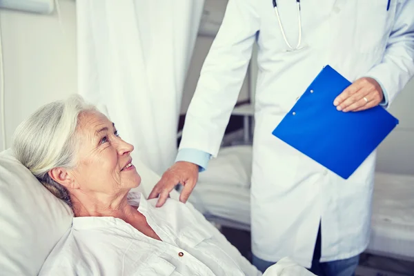 Médecin visitant heureuse femme âgée à l'hôpital — Photo