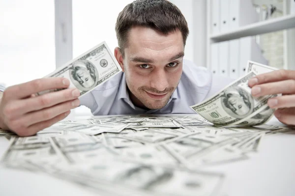 Happy affärsman med högen av pengar i office — Stockfoto