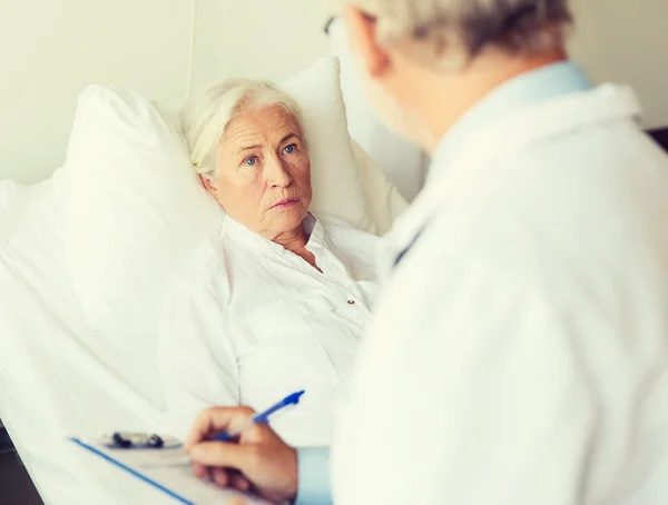 Idős nő és orvos írótáblával a kórházban — Stock Fotó