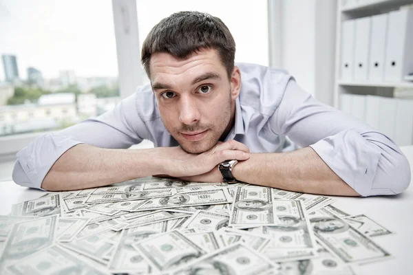 Hombre de negocios feliz con un montón de dinero en la oficina —  Fotos de Stock