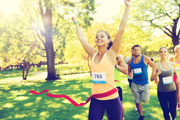 Feliz joven corredor femenino ganar en la carrera final — Foto de Stock