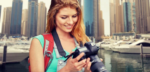 Mulher com mochila e câmera sobre a cidade de Dubai — Fotografia de Stock