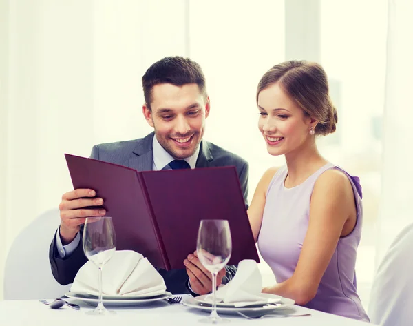 Pareja sonriente con menú en el restaurante — Foto de Stock