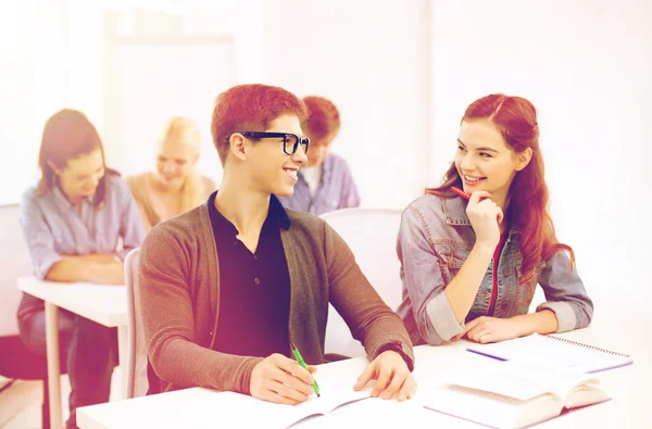 Studenti sorridenti con quaderni a scuola — Foto Stock