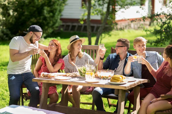 Happy friends having dinner at summer garden party — Stock Photo, Image