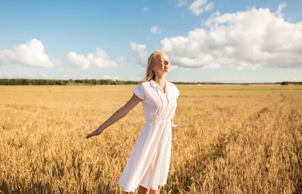 Jeune femme souriante en robe blanche sur le champ de céréales — Photo
