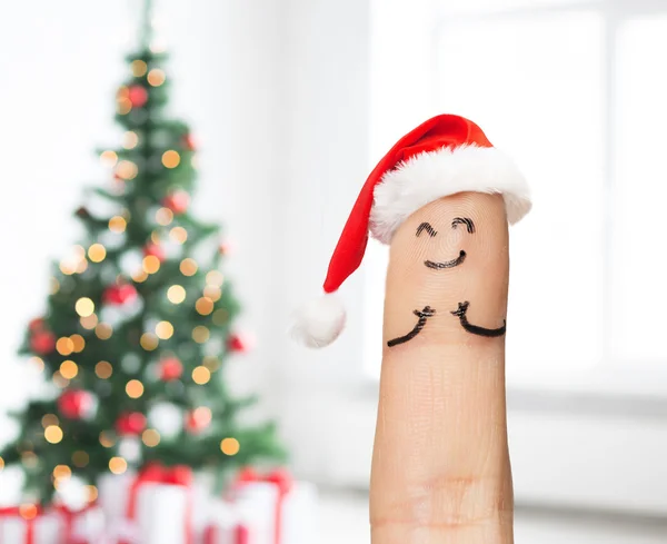 Närbild på ett finger i Santa hat — Stockfoto