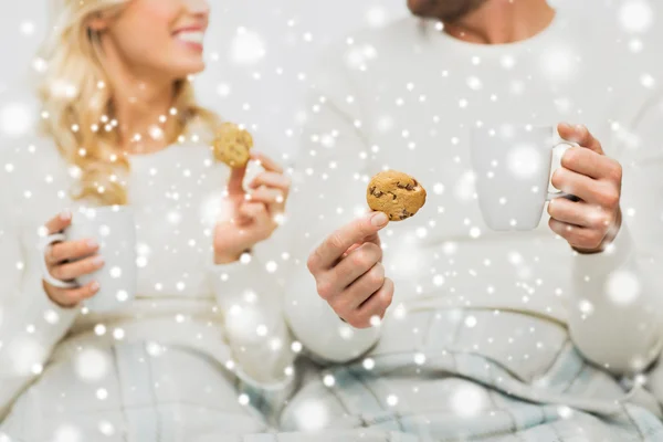 Nahaufnahme eines glücklichen Paares mit Keksen und Teetassen — Stockfoto