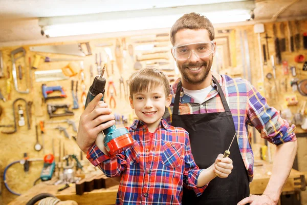 Padre e hijo con taladro trabajando en el taller — Foto de Stock
