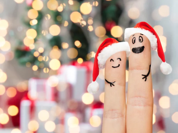 Nahaufnahme von zwei Fingern mit Smiley und Weihnachtsmützen — Stockfoto