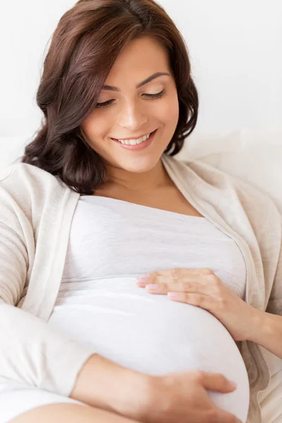 Glücklich schwangere Frau zu Hause im Bett liegend — Stockfoto