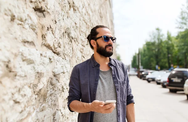 Άνθρωπος με smartphone στο πέτρινο τοίχο — Φωτογραφία Αρχείου