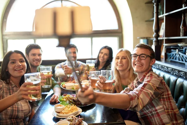 Glückliche Freunde mit Selfie-Stick in Bar oder Kneipe — Stockfoto