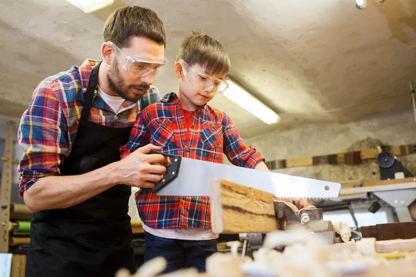 Padre e hijo con sierra trabajando en el taller —  Fotos de Stock