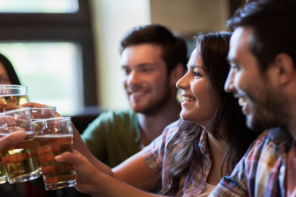 Счастливые друзья пьют пиво в баре или пабе — стоковое фото