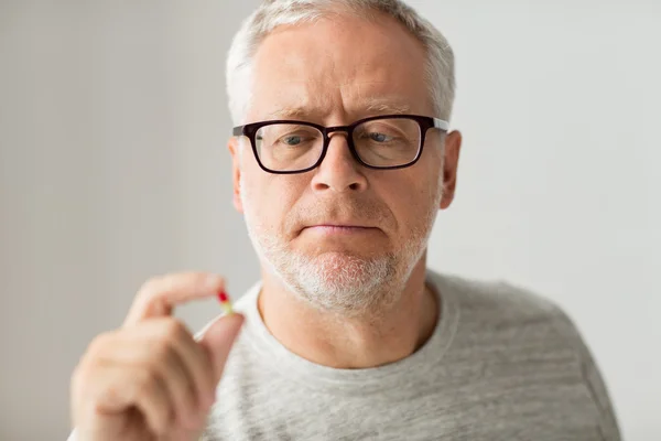 Nahaufnahme eines älteren Mannes, der Medikamententabletten nimmt — Stockfoto