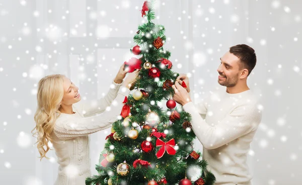 크리스마스 트리 장식을 하고 있는 행복 한 부부 로열티 프리 스톡 사진