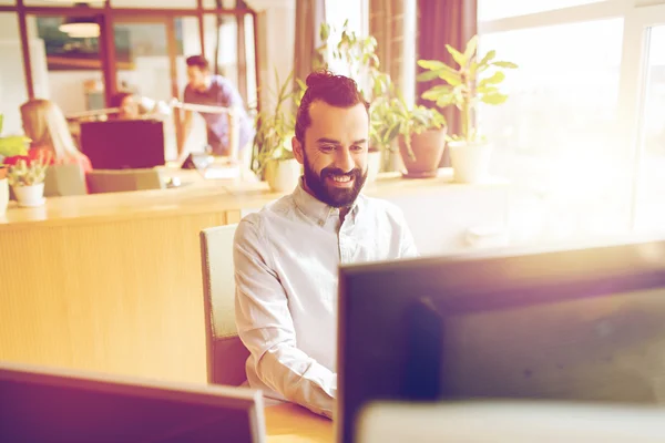 Gelukkig creatieve mannelijke kantoor werknemer met computer — Stockfoto