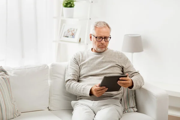 Äldre man med TabletPC hemma — Stockfoto