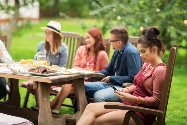 Mulher com smartphone e amigos na festa de verão — Fotografia de Stock